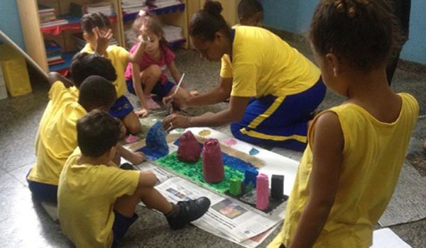 volunteer teaching painting to school kids