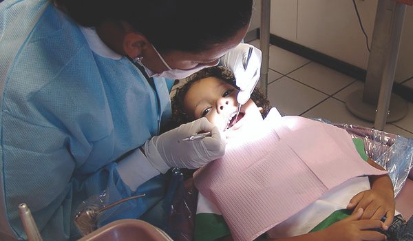 volunteer checking teeth of child