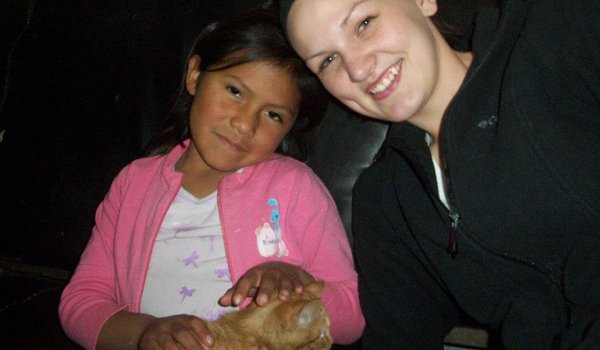 volunteer and orphan kids playing with cat