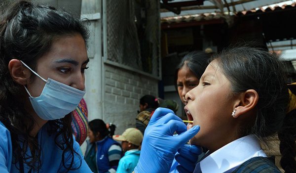 volunteer checking school kids teeth