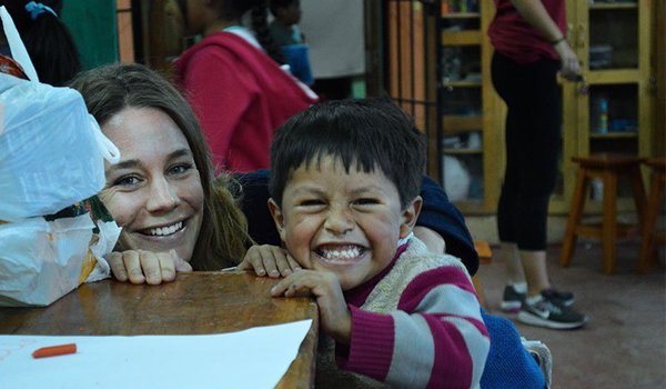 volunteer and child tease other kids in orphanage