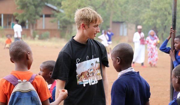 volunteer playing with child in uganda orphanage