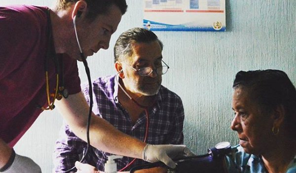 volunteer measuring blood pressure of patient