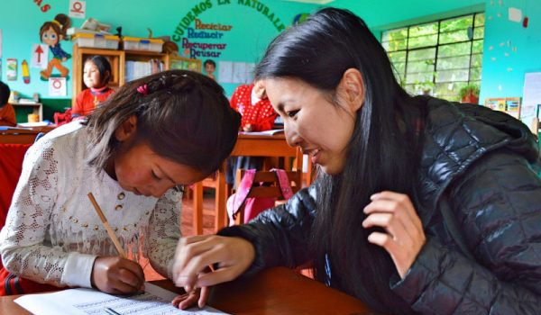 volunteer-assisting-child-in-completing-classwork