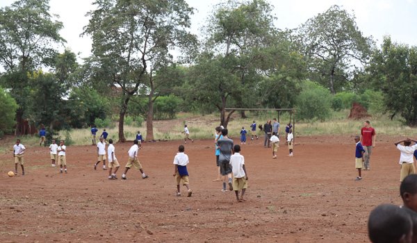 student playing football with volunteer in south africa