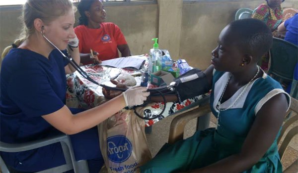 volunteer having a primary health checkup of patient in uganda