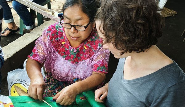 elderly-woman-teach-volunteer-to-make-garment-product