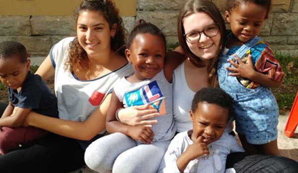 Happy volunteers cherishing disadvantaged children